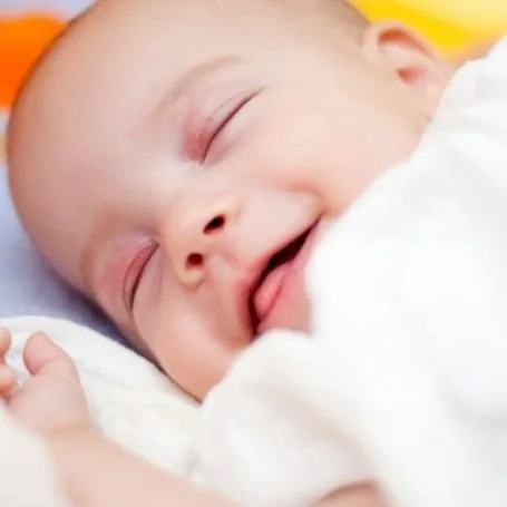 Bebé dormido y sonriendo después de la sesión