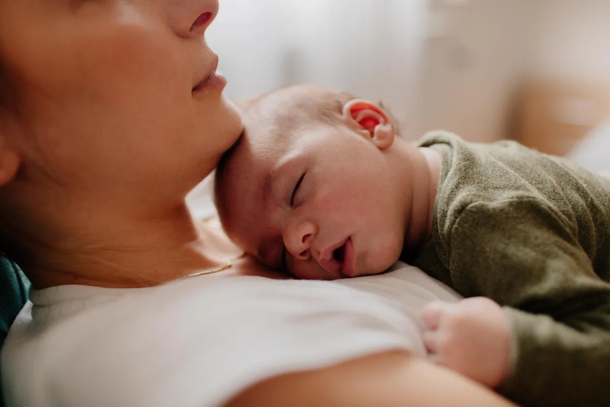 Madre con su bebé dormido sobre el pecho